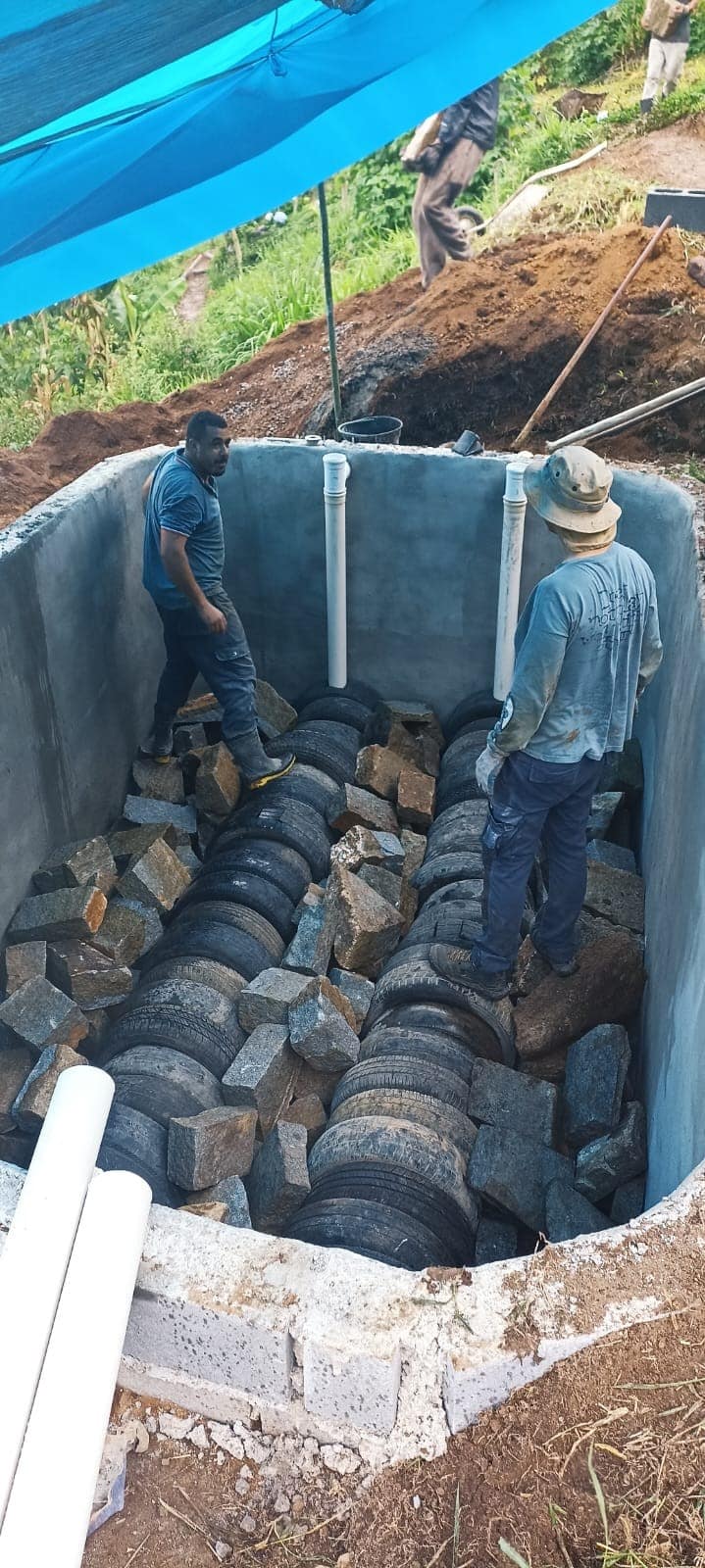 primeira camada de materiais: pneus e pedra rachão.